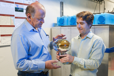 Jason Newby and co-author Yuri Efremenko hold the remarkably small 14.6 kg cesium iodide neutrino detector used to search for dark matter at Neutrino Alley