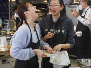 First-year Laura Han, left, and sophomore Dasol Lee share a laugh while spherifying orange juice using sodium alginate and calcium chloride.